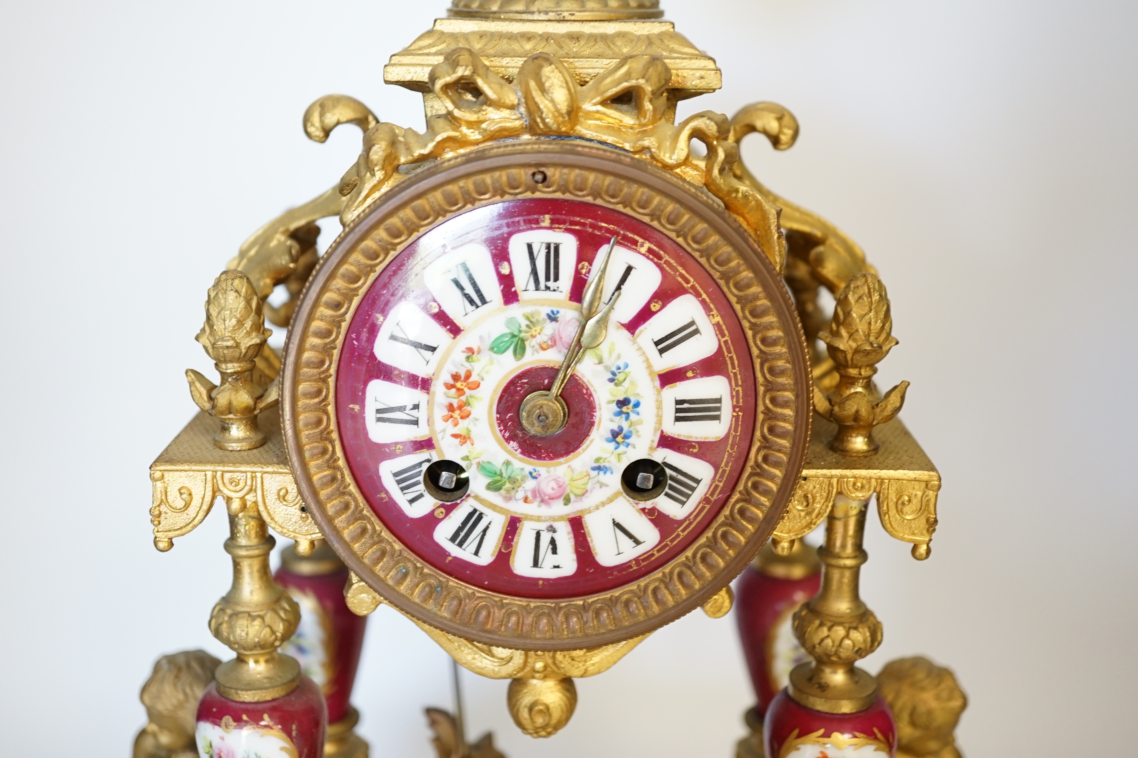 A late 19th century gilt metal and porcelain mounted mantel clock with associated stand, key and pendulum, 46cm. Condition - good to fair, not tested